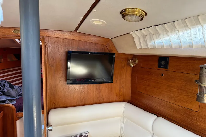 Slide: The Image of Interior of 1987 Moody 346 yacht with TV, wood paneling, and white seating. - 11