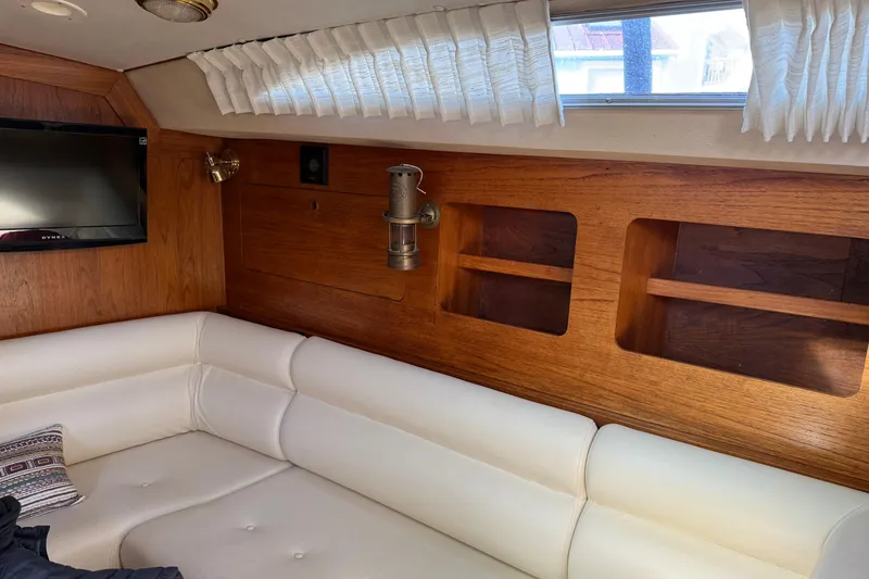 Slide: The Image of Interior of 1987 Moody 346 yacht with white seating and wooden paneling. - 12