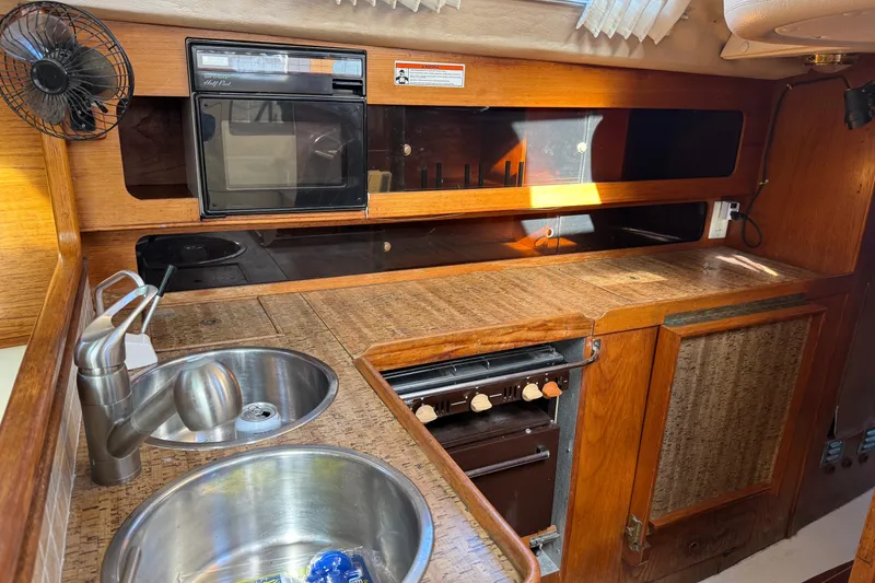 Slide: The Image of Compact kitchen in 1987 Moody 346 yacht with sink, stove, and wooden cabinetry. - 13