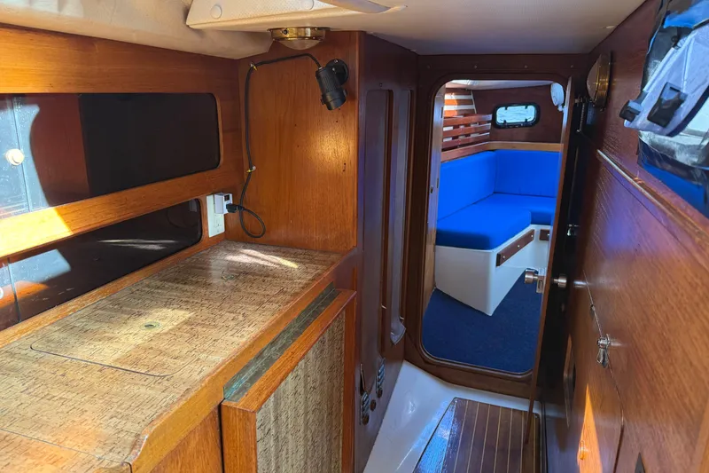 Slide: The Image of Interior of a 1987 Moody 346 sailboat with wooden cabinetry and blue seating. - 14
