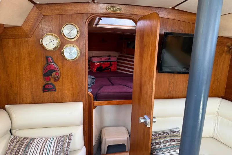 Slide: The Image of Cozy 1987 Moody 346 yacht interior with wood paneling, instruments, and comfortable seating. - 16