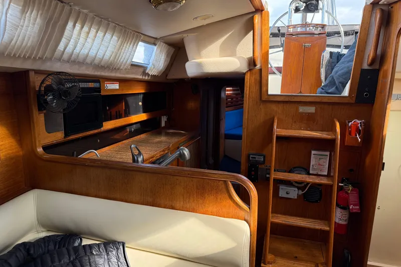 Slide: The Image of Interior of 1987 Moody 346 sailboat with wooden cabinetry and cozy seating area. - 18
