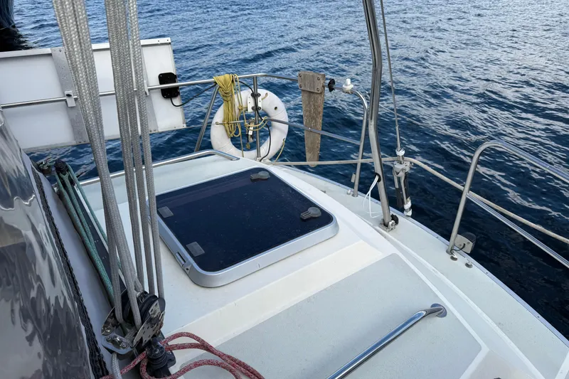 Slide: The Image of Sailboat deck of 1987 Moody 346 on calm water, featuring ropes and a lifebuoy. - 25