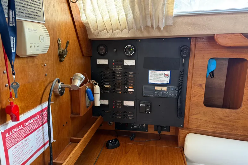 Slide: The Image of Electrical panel inside a 1987 Moody 346 sailboat, featuring switches, gauges, and communication equipment. - 8