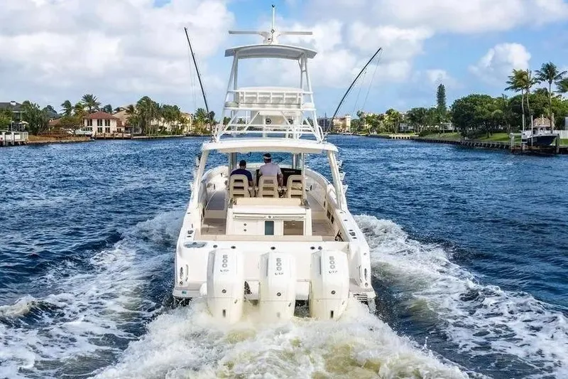 Slide: The Image of 2022 Boston Whaler 420 Outrage cruising on a scenic waterway with palm trees. - 13