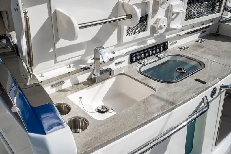 Slide: The Image of Boston Whaler 420 Outrage 2022 boat kitchen with sink and control panel. - 22