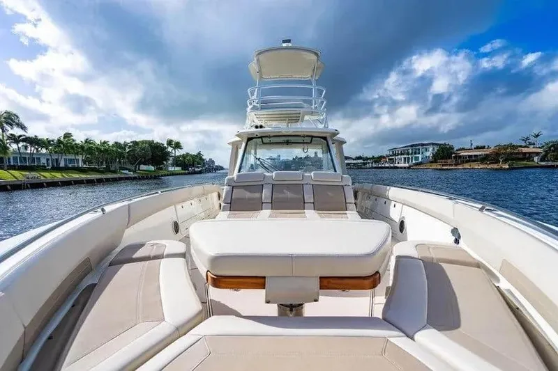 Slide: The Image of Boston Whaler 420 Outrage 2022 on a scenic waterway, showcasing luxury seating and sleek design. - 36