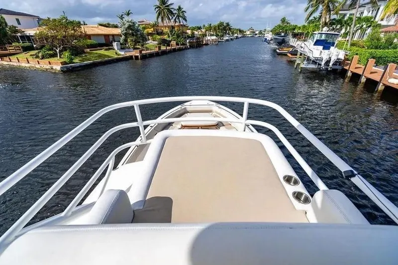 Slide: The Image of 2022 Boston Whaler 420 Outrage cruising through a scenic canal with palm trees. - 39