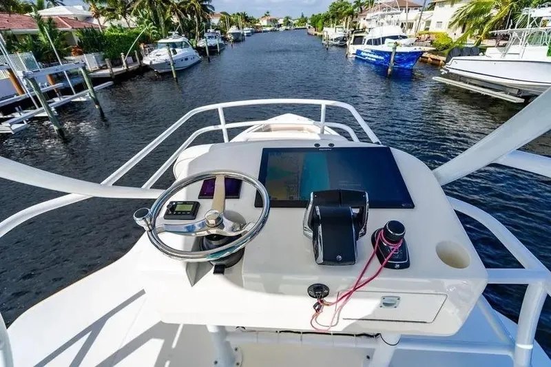 Slide: The Image of Helm of 2022 Boston Whaler 420 Outrage overlooking a scenic waterway. - 41