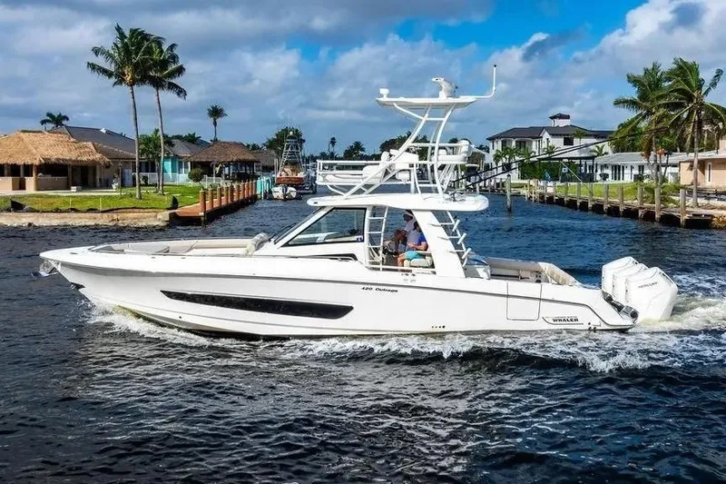 Slide: The Image of 2022 Boston Whaler 420 Outrage cruising on a scenic waterway with palm trees. - 5