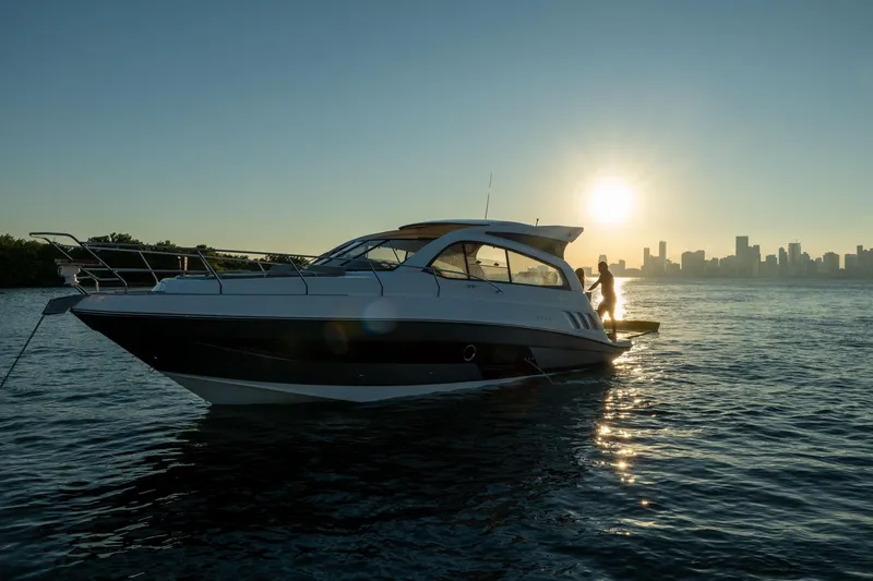 Slide: The Image of Luxury Hanover 375 yacht on water at sunset, city skyline in background, 2026 model. - 111