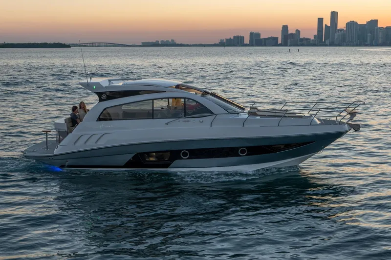 Slide: The Image of 2026 Hanover 375 yacht cruising at sunset near city skyline. - 115