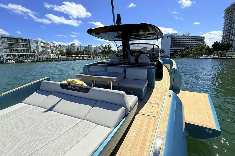 Slide: The Image of Luxurious 2022 Solaris Power 44 yacht with spacious deck and modern seating, docked by waterfront buildings. - 13