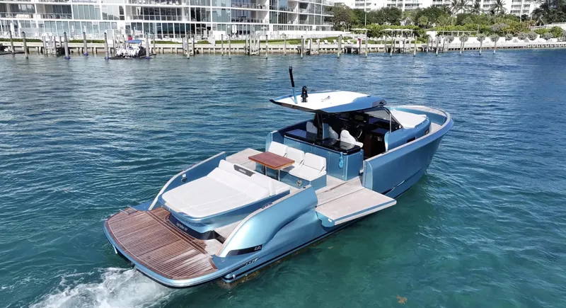 Slide: The Image of 2022 Solaris Power 44 yacht cruising on clear blue water near a marina. - 4