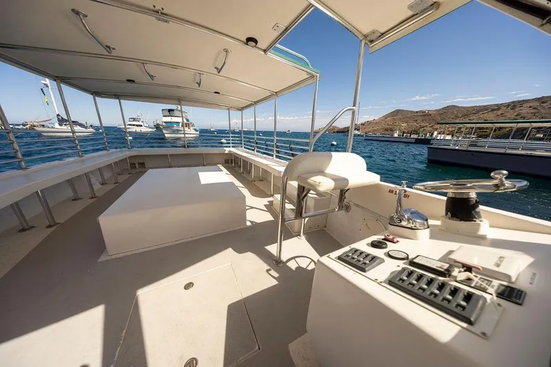 Slide: The Image of 2018 Seahawk Island Hopper boat interior with control panel, docked in a scenic marina. - 9