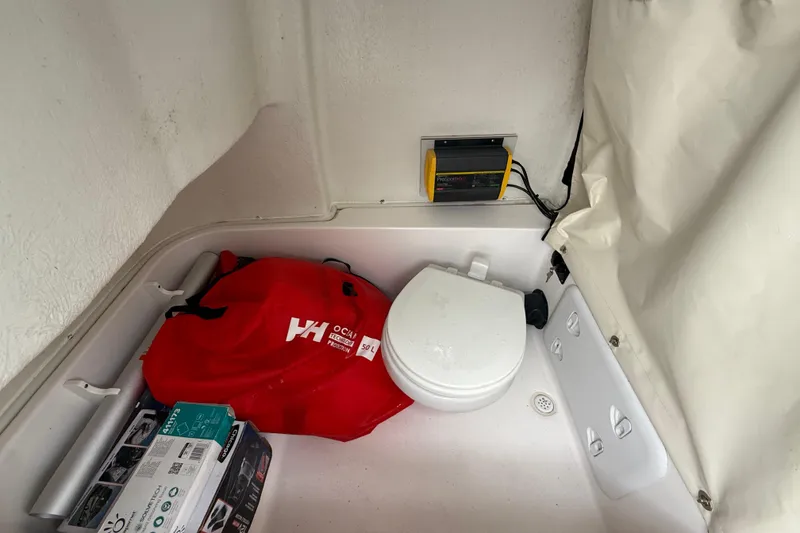 Slide: The Image of 2023 Sea Fox 248 Commander boat interior with toilet, red bag, and charger. - 30