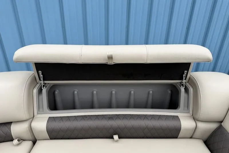 Slide: The Image of 2023 Sun Tracker SportFish 20 DLX boat seat storage compartment open, blue background. - 11