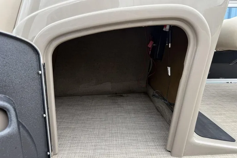 Slide: The Image of 2023 Sun Tracker SportFish 20 DLX storage compartment with carpeted interior and wiring. - 18