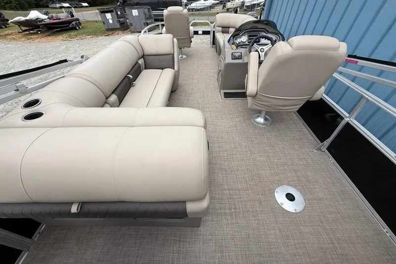 Slide: The Image of 2023 Sun Tracker SportFish 20 DLX pontoon boat interior with beige seating and helm. - 28