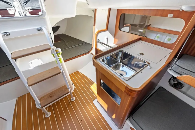 Slide: The Image of Interior of 2011 J Boats J 111 sailboat with wooden flooring and compact kitchen area. - 26
