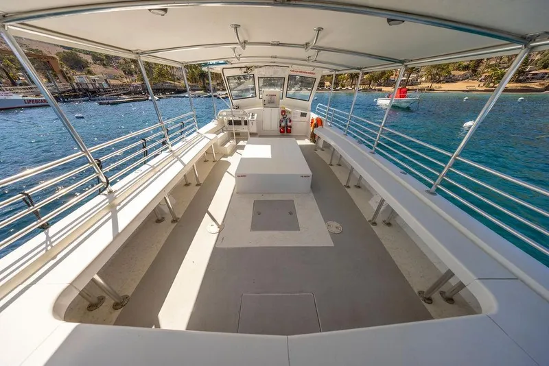 Slide: The Image of 2018 Seahawk Island Hopper boat interior with seating, docked by a scenic waterfront. - 11