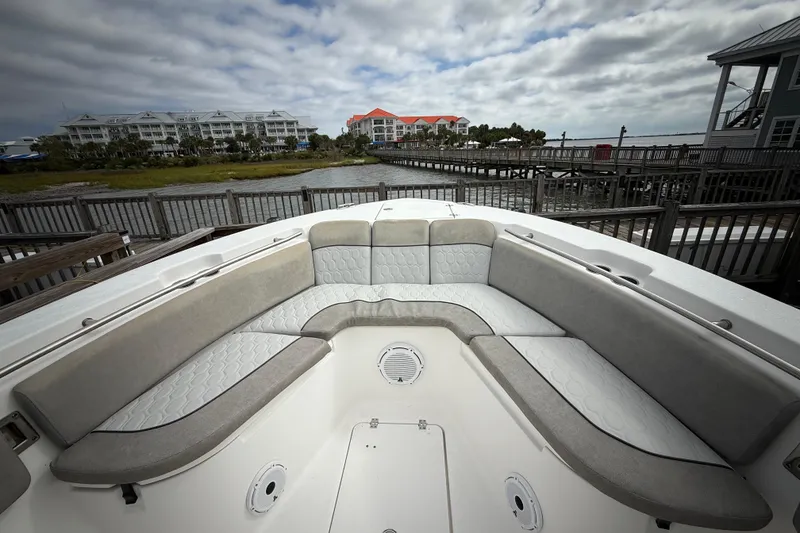 Slide: The Image of 2022 Sea Fox 288 Commander boat interior with cushioned seating, dockside view. - 15