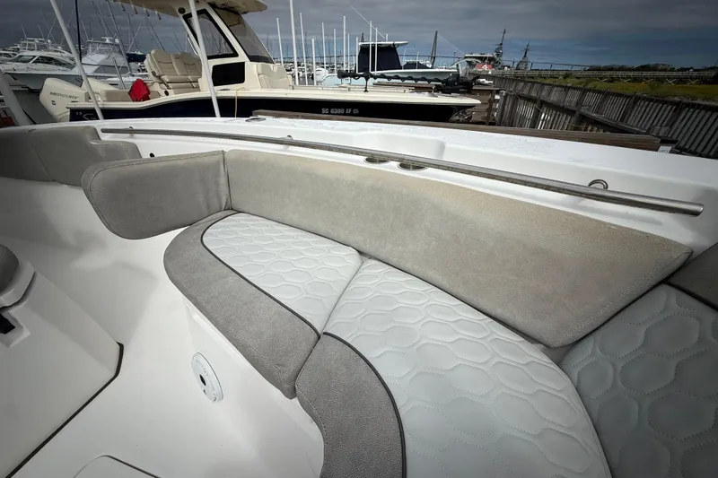 Slide: The Image of 2022 Sea Fox 288 Commander boat with cushioned seating in a marina setting. - 17
