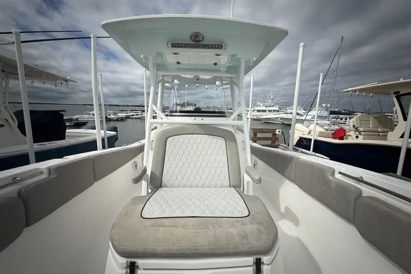 Slide: The Image of 2022 Sea Fox 288 Commander boat interior at marina, showcasing seating and helm. - 18