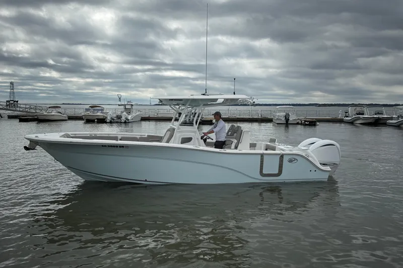 Slide: The Image of 2022 Sea Fox 288 Commander boat on water, cloudy sky, marina background. - 2