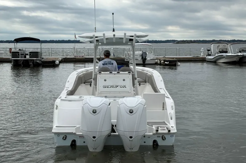 Slide: The Image of 2022 Sea Fox 288 Commander boat docked with twin engines, overcast sky. - 5