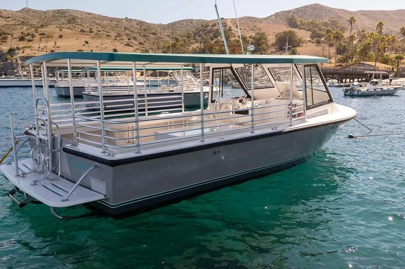 Slide: The Image of 2019 Seahawk Island Hopper boat docked in scenic marina with hills in background. - 17