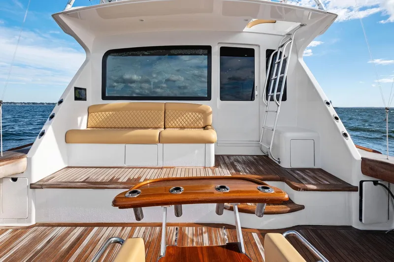 Slide: The Image of 2001 Viking 61 yacht "Bait Waster" cruising on open water, featuring a spacious deck. - 6