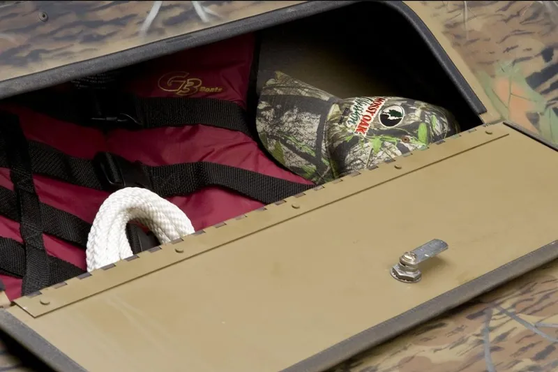 Slide: The Image of Open storage compartment in G3 16DK boat with life jacket, rope, and camo hat. - 11