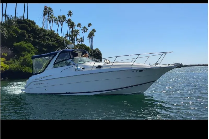 The Image of 2000 Monterey 302 Cruiser boat on water near palm trees and greenery. - 1