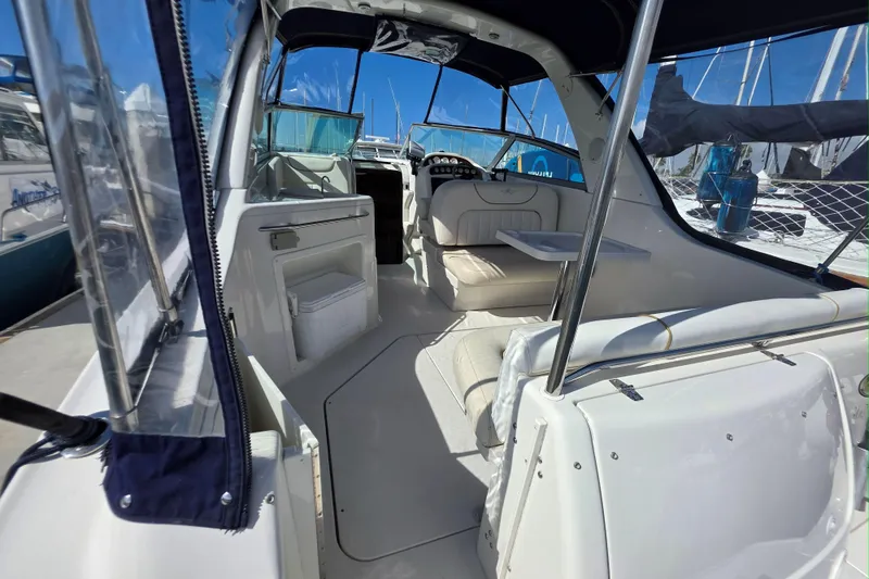 Slide: The Image of 2000 Monterey 302 Cruiser interior with seating and table, docked at marina. - 13