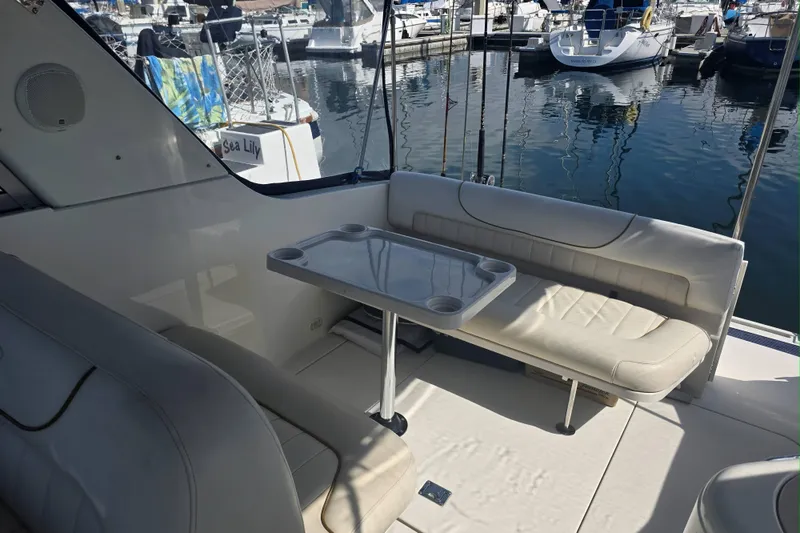 Slide: The Image of Interior of a 2000 Monterey 302 Cruiser with seating and table, docked at a marina. - 14