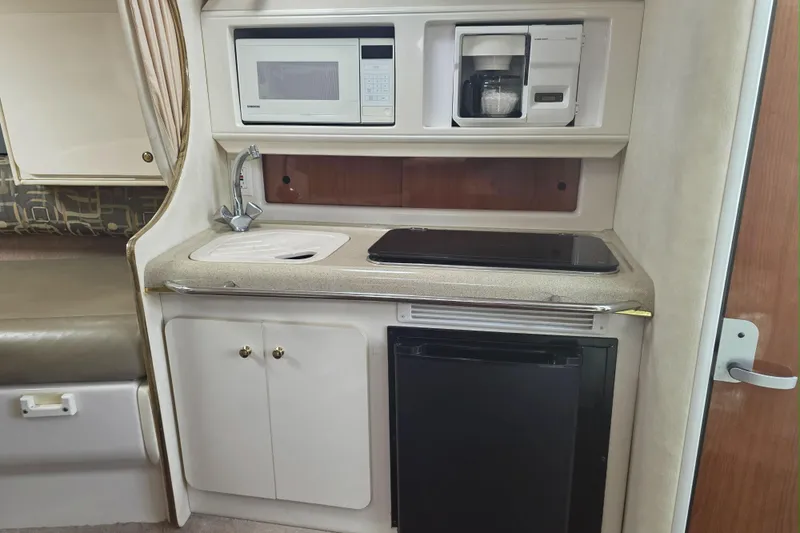 Slide: The Image of Compact kitchen in a 2000 Monterey 302 Cruiser with microwave, sink, and mini fridge. - 7