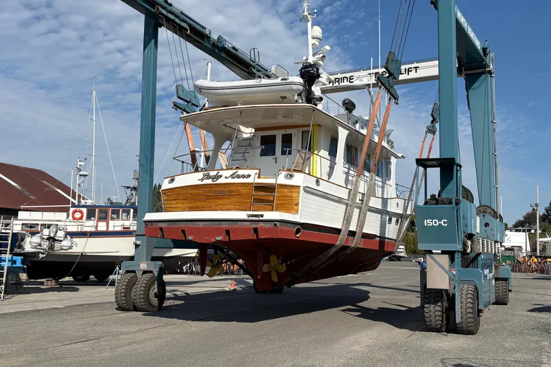 Slide: The Image of Grand Banks 52 Europa yacht being lifted by a boat hoist in a shipyard. - 18