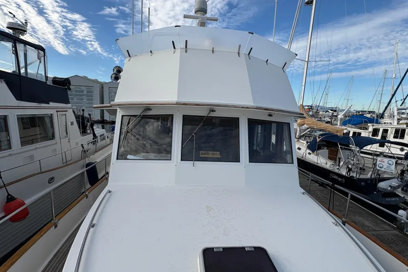 Slide: The Image of 1998 Grand Banks 52 Europa yacht docked at marina under cloudy skies. - 2