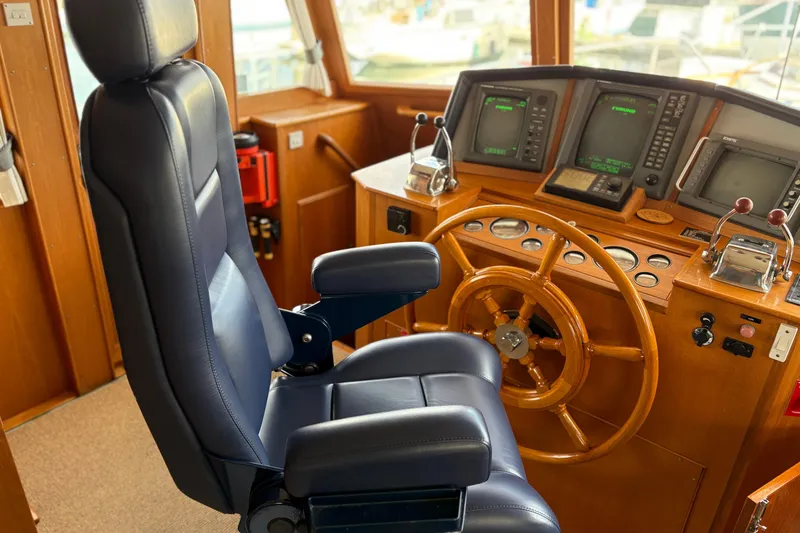 Slide: The Image of 1998 Grand Banks 52 Europa yacht kitchen with stove, wooden cabinets, and window view. - 28