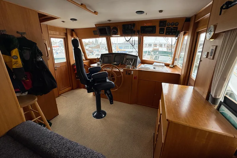 Slide: The Image of Captain's chair and helm of 1998 Grand Banks 52 Europa yacht, featuring navigation equipment. - 29