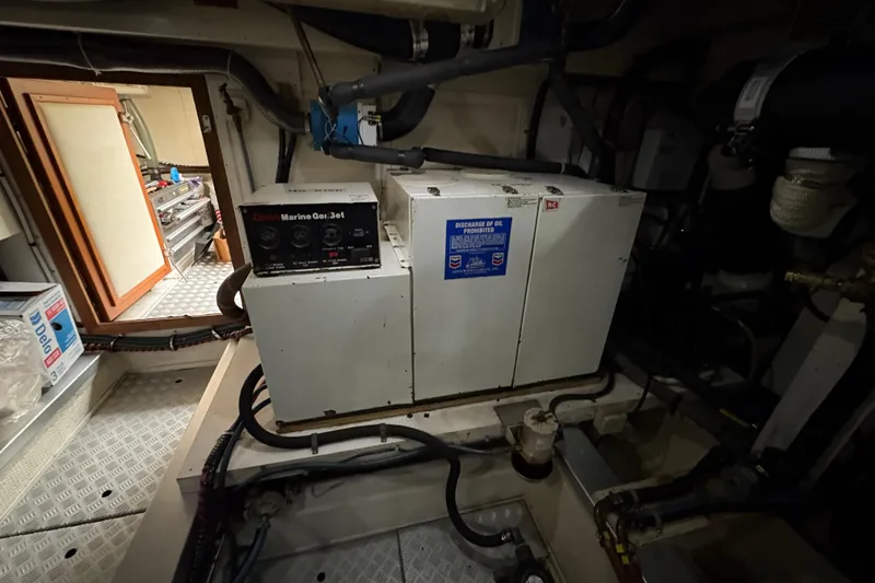 Slide: The Image of Engine room of a 1998 Grand Banks 52 Europa yacht with visible machinery and wiring. - 50