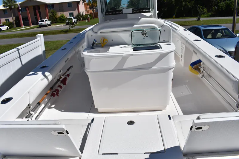 Slide: The Image of 2018 Everglades 273 Center Console boat interior with fishing gear and storage compartments. - 7