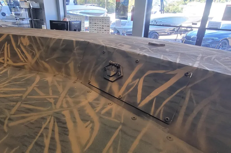 Slide: The Image of Camouflage-patterned surface of a 2026 G3 17CC boat in a showroom setting. - 11