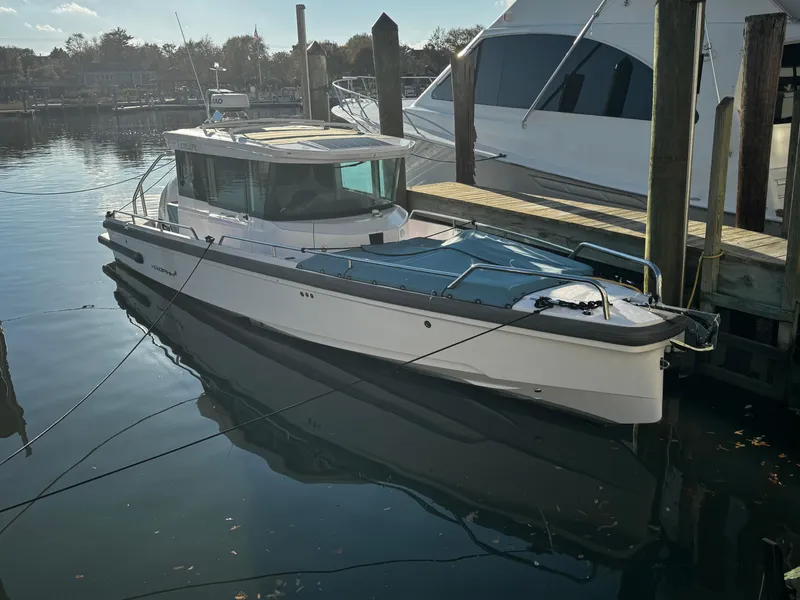 The Image of 2023 Axopar 28 CABIN boat docked in a serene marina setting. - 0