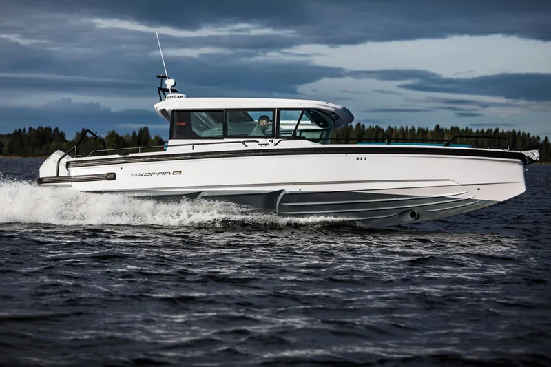 Slide: The Image of 2023 Axopar 28 CABIN cruising on a lake under cloudy skies. - 13