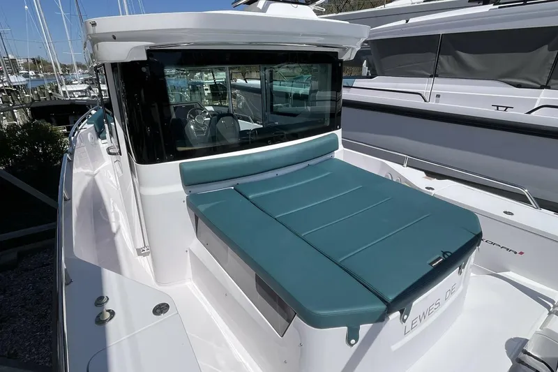 Slide: The Image of 2023 Axopar 28 Cabin boat with teal seating, docked in a marina. - 14