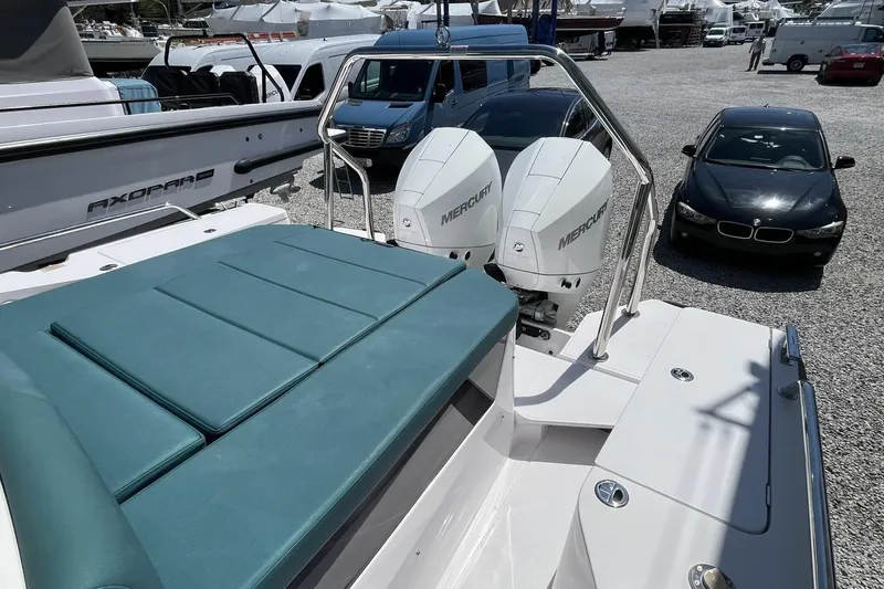 Slide: The Image of 2023 Axopar 28 Cabin boat with dual Mercury engines, parked near cars. - 16