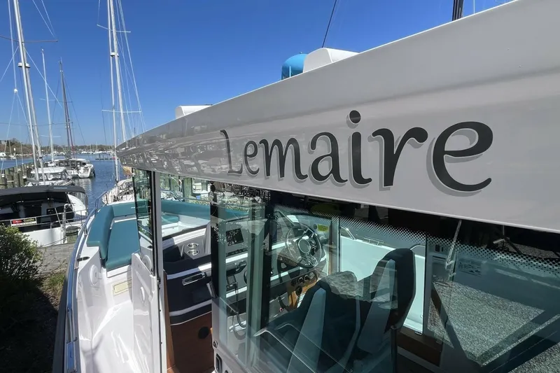 Slide: The Image of 2023 Axopar 28 Cabin boat named "Lemaire" docked at a marina. - 17