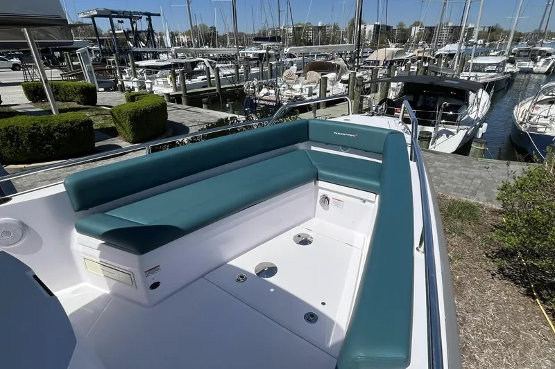 Slide: The Image of 2023 Axopar 28 Cabin boat with teal seating at a marina dock. - 19